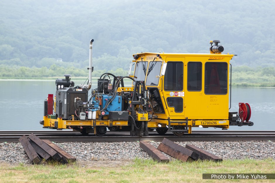 The gang arrived at milepost 317.6 at 9:22 am on Friday, June 25. The first machines are spike pullers. This line of machines was moving from right to left. Piles of new ties are at foreground. 